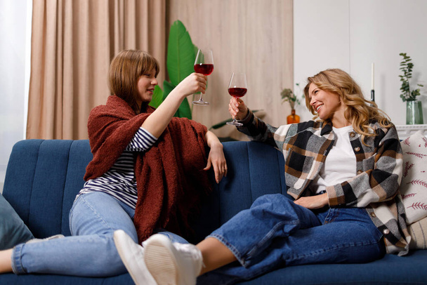Мать и дочь веселятся, звоня бокалами вина. - Фото, изображение