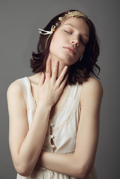 Sweet sensuality. A beautiful young woman wearing vintage clothing and posing with eyes closed and hand on her neck - Fotoğraf, Görsel