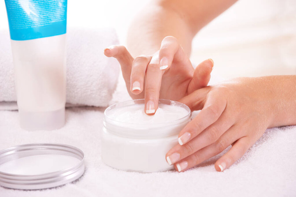 Les soins de la peau sont son objectif principal. une femme tenant un pot de crème pour les mains - Photo, image