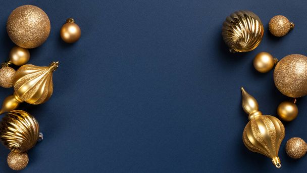 Christmas banner frame with golden glitter balls and toys on blue background with copy space - Fotoğraf, Görsel