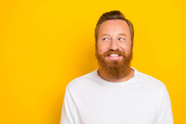 Closeup photo of young handsome cute man red beard mustache smiling look tricky empty space idea isolated on yellow color background. - Valokuva, kuva
