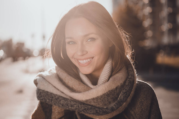 Photo of shiny charming woman wear grey coat warm scarf smiling enjoying morning sunshine outside urban city street. - Фото, изображение