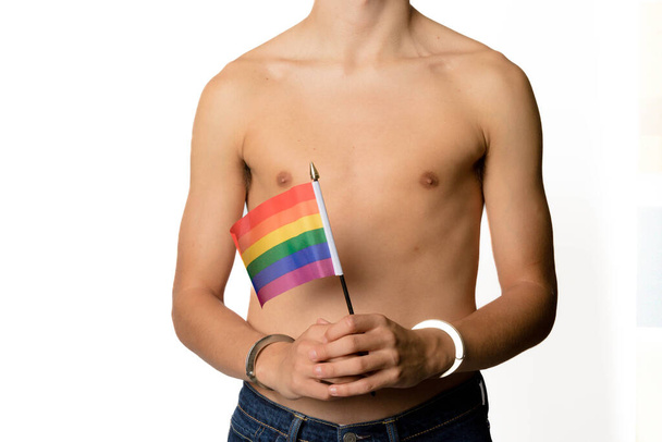 A Shirtless 19 Year Old Teenage Boy with Pride Flags in Handcuffs - Fotoğraf, Görsel