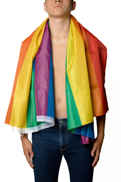 A Shirtless 19 Year Old Teenage Boy wrapped in A Pride Flag - 写真・画像