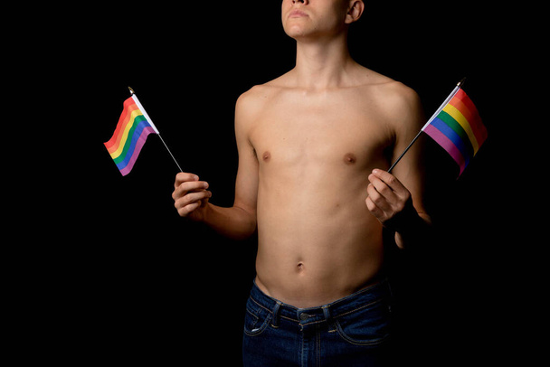 Un ragazzo adolescente senza maglietta di 19 anni con le bandiere dell'orgoglio - Foto, immagini