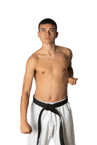 A Shirtless 19 Year Old Practacing a Karate Groin Block - 写真・画像