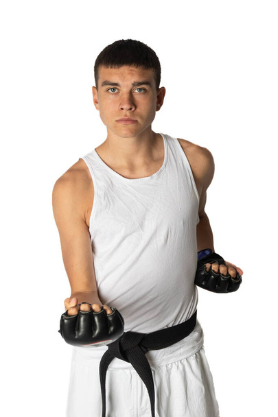 19 Year Old Practacing a Karate Short Punch wearing fighting gloves - Foto, imagen