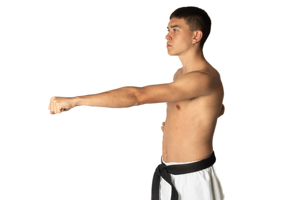 A Shirtless 19 Year Old Practacing a Karate Stomach Punch - Foto, afbeelding