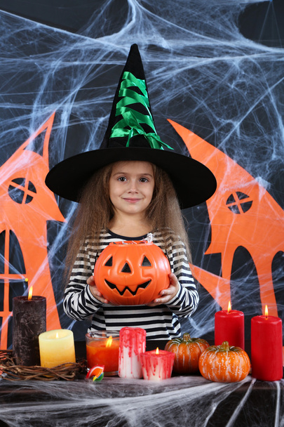 Little girl Witch in hat on Halloween decorations background - Fotoğraf, Görsel