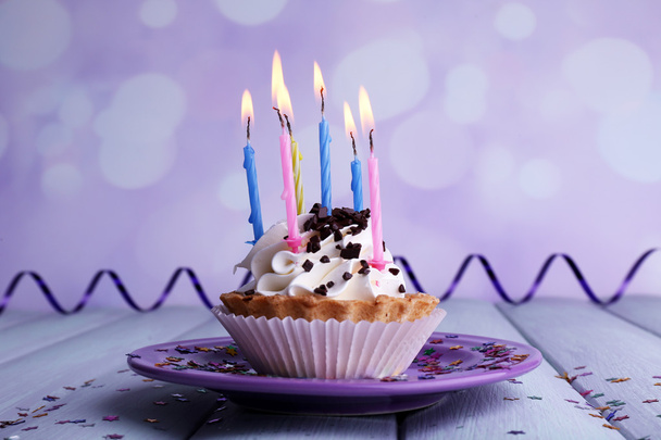 Urodziny ciasto ze świecami na tabliczce na drewnianym stole i tło światło - Zdjęcie, obraz