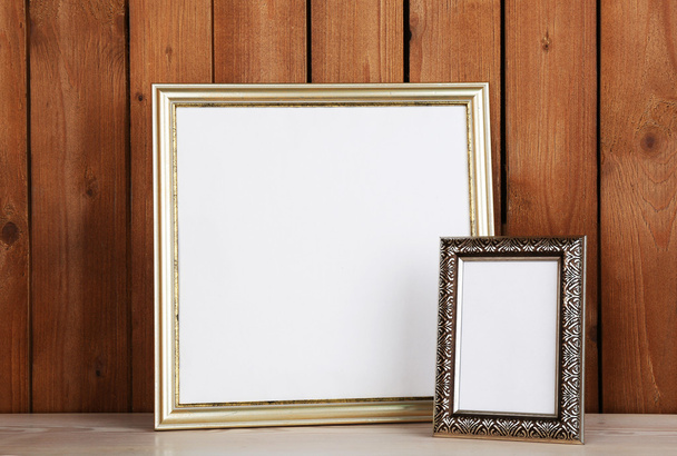 Photo frames on wooden surface and wooden wall background - Foto, Bild