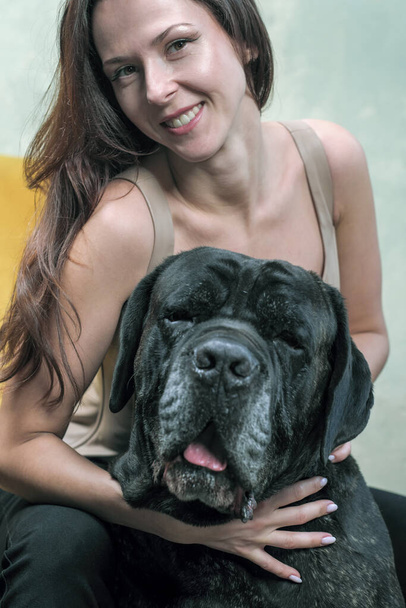 Junge schlanke süße Mädchen mit einem Hund der italienischen Rasse Cane Corso Porträt im Studio - Foto, Bild