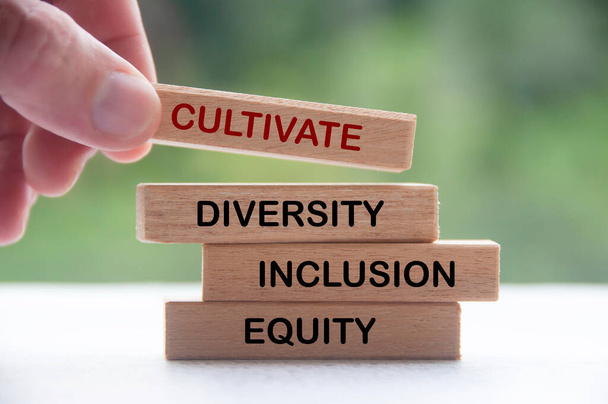 Bloc de bois à main avec texte - Cultiver la diversité, l'inclusion et l'équité. Concept de culture d'entreprise. - Photo, image
