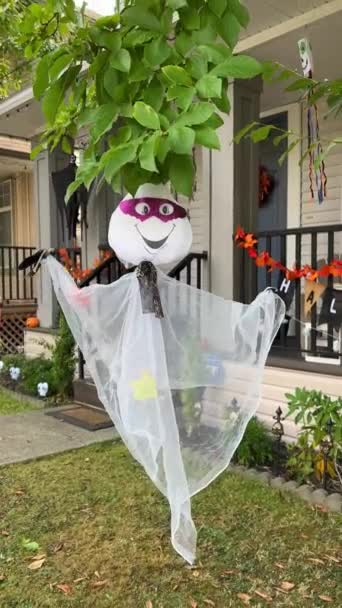 サリー・バンクーバー・カナダの民家を背景にした小さな面白い幽霊や木にかかって白い透明生地から手作りされています。顔にはバットマンのマスクが付いてる - 映像、動画