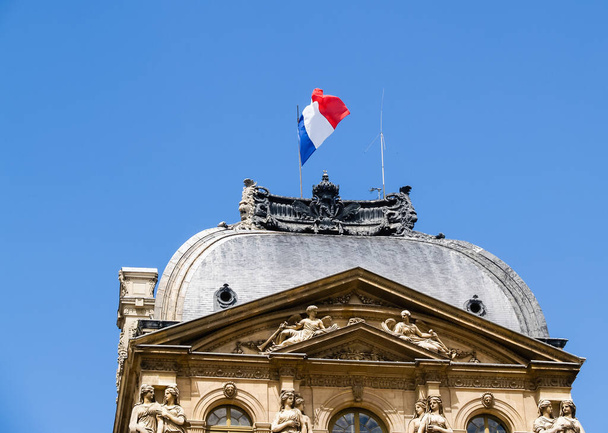 Прапор Франції над старовинній будівлі зі складними фігурки і архітектурні особливості. - Фото, зображення