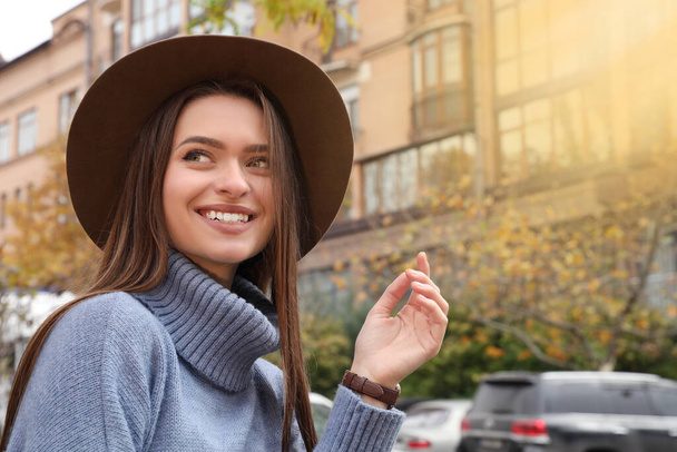 Beautiful young woman wearing stylish autumn clothes on city street - Fotografie, Obrázek