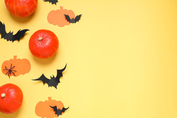 Flat lay composition with paper bats, pumpkins and spider on yellow background, space for text. Halloween decor - Foto, Imagen