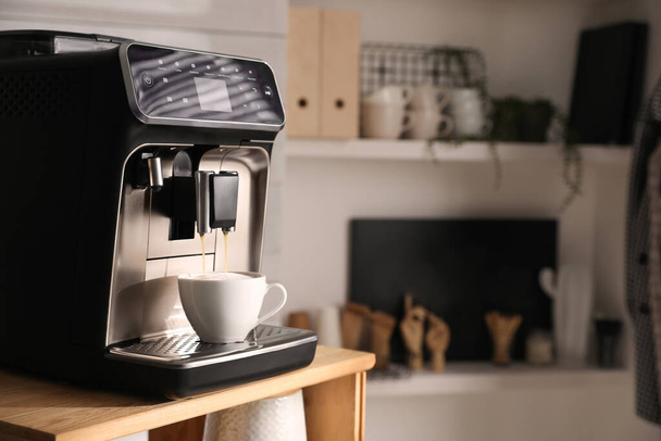 Modern coffee machine making tasty drink in office kitchen, space for text - Zdjęcie, obraz