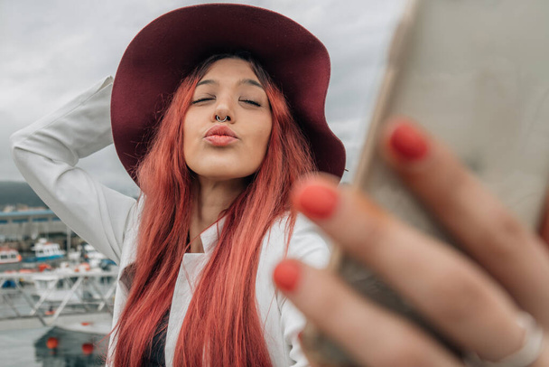 urban hipster girl with mobile phone kissing at camera - Photo, Image