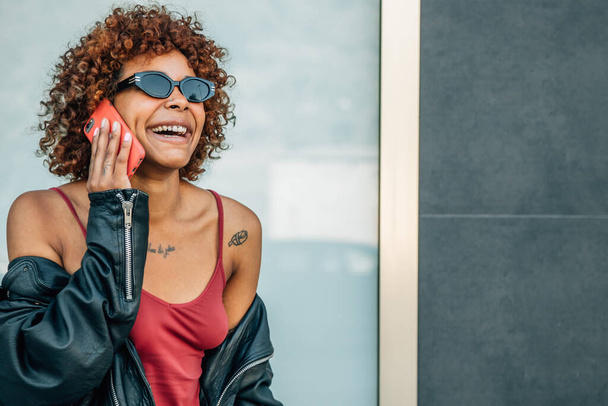 sorridente ragazza afro-americana che parla sul cellulare per strada - Foto, immagini
