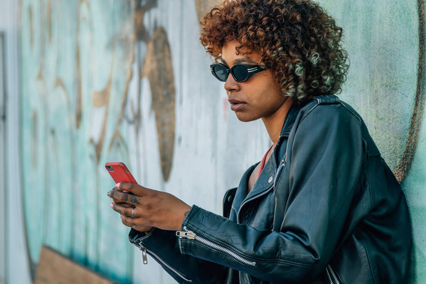 miejska dziewczyna z telefonem komórkowym na ulicy - Zdjęcie, obraz