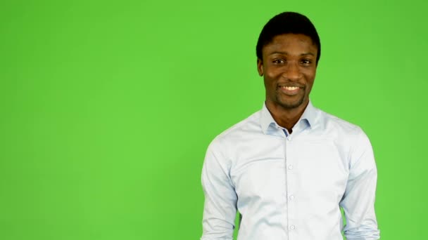 Young handsome black man smiles - green screen - studio - Footage, Video