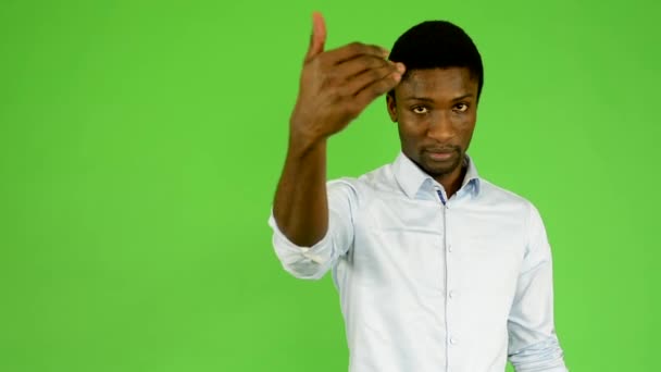 Young handsome black man invites - green screen - studio - Felvétel, videó