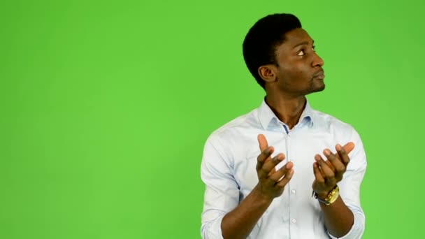Młody przystojny czarny człowiek jest zaskoczony - zielony ekran - studio - Materiał filmowy, wideo