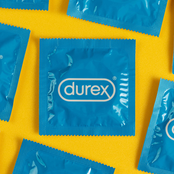 Lviv, Ukraine - August 02, 2022. Durex condoms on yellow background. Pattern, top view. - Fotó, kép
