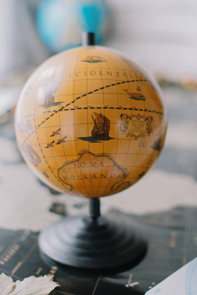 Brązowy glob na mapie świata z zamazanym tłem. - Zdjęcie, obraz