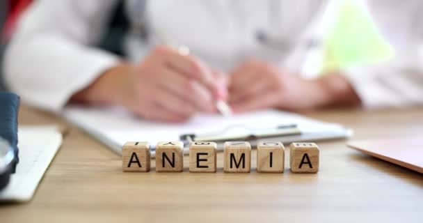 Médico mano mujer escribe el diagnóstico de anemia historial médico. La anemia causa síntomas de la enfermedad - Metraje, vídeo