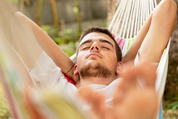 junger Mann schläft im Sommer in der Hängematte - Foto, Bild