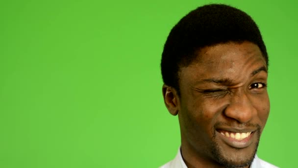 Young handsome black man winks the eye- green screen - studio - closeup - Footage, Video