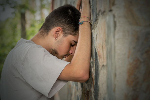 joven deprimido apoyado en la pared - Foto, imagen