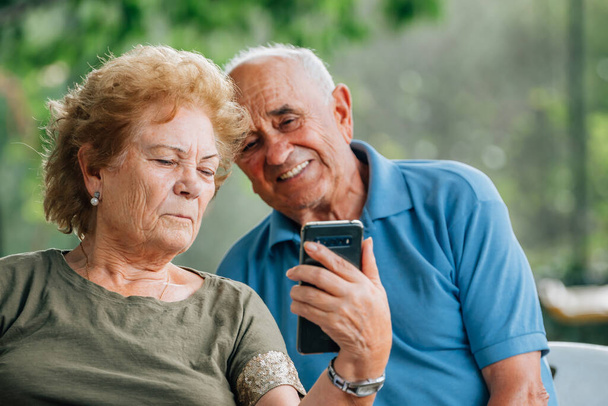 pareja mayor con teléfono móvil hablando en videollamada - Foto, Imagen