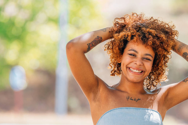 chica negra latinoamericana sonriendo en voz alta al aire libre - Foto, imagen
