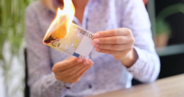 Woman holds burning two hundred Eurozone banknote. Flame of fire from euro union cash. Financial crisis and depressed economy. - Footage, Video