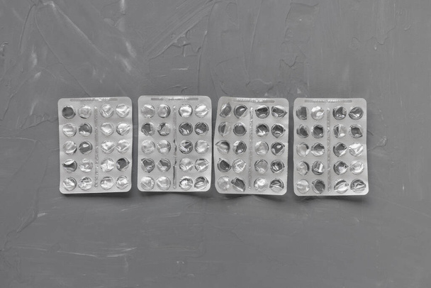 Envases de blister vacíos de píldoras sobre fondo gris, suplemento y concepto de medicina. Primer plano, vista superior, espacio para copiar - Foto, imagen