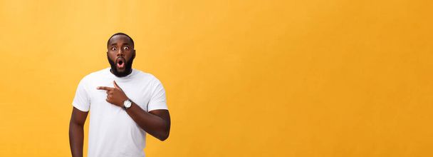 Hämmästyttävä nuori afroamerikkalainen hipsteri valkoisessa t-paidassa pitämässä käsiään yllättyneenä eleenä, pitäen suu auki, näyttäen järkyttyneeltä
. - Valokuva, kuva