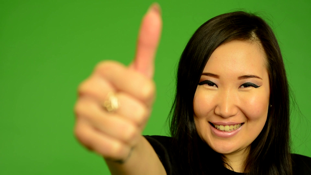 Młoda atrakcyjna kobieta Azji pokazuje kciuk na umowy - zielony ekran studio - zbliżenie - Materiał filmowy, wideo