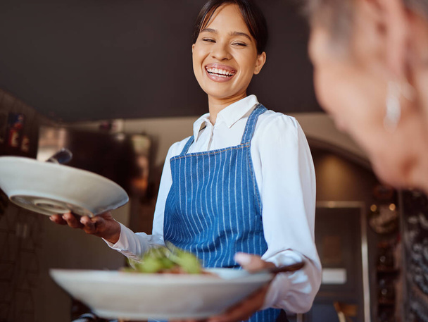 Waitress in a restaurant, serving customer her food, healthy salad and gives service with a smile. Woman in the hospitality industry, friendly laugh and happy to provide diet meal for lunch or dinner. - Photo, Image