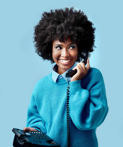Σταθερή γραμμή, επικοινωνία και μαύρη γυναίκα να μιλάει σε ένα τηλέφωνο με φόντο ένα μπλε στούντιο. Ευτυχισμένος, χαμόγελο και νεαρό αφρικανικό μοντέλο μιλώντας σε επαφή σε ένα vintage τηλέφωνο με mock up χώρο. - Φωτογραφία, εικόνα