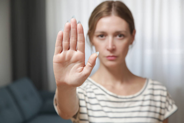 Serious worried young woman making hand stop gesture expressing fighting for equal rights against domestic violence, abuse, discrimination, bullying, sexual or racial discrimination. - Foto, Bild