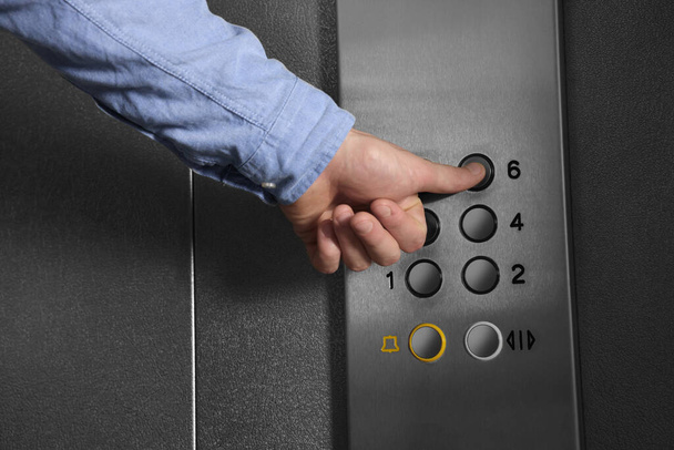 Man choosing floor in elevator, closeup view - Foto, immagini