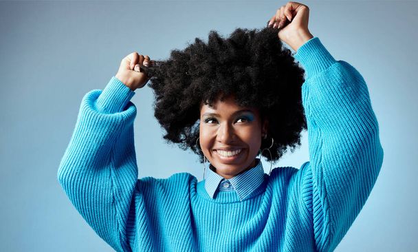 青のスタジオのモックアップの背景に対してアフロと幸せ、黒の女性と健康的な自然な髪。スムーズな輝く肌とファッションで流行、美しさとエンパワメントを探して若い美しい女性モデル. - 写真・画像