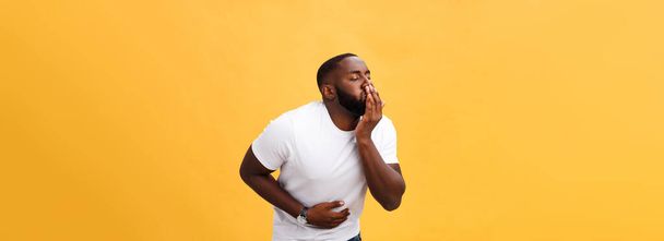 Mladý Američan Afričana muž na sobě bílé tričko s rukou na žaludek, protože nevolnost, bolestivé nemoci, pocit nevolnosti. Bolest koncept. - Fotografie, Obrázek