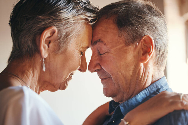 Love, support and elderly couple hug, commitment and understanding in their home together. Wellness, intimate and romantic seniors enjoy soulmate connection while bonding with affection and romance. - Fotó, kép