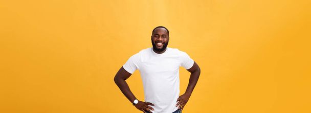 Portrait d'un jeune homme noir moderne souriant debout sur fond jaune isolé
. - Photo, image