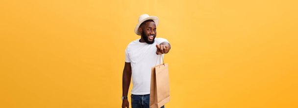 African American man with colorful paper bags isolated on yellow background. - Fotoğraf, Görsel