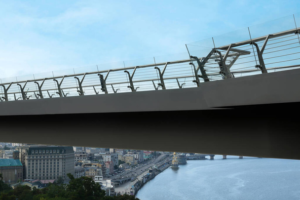 KYIV, UKRAINE - AUGUST 11, 2022: Pedestrian park bridge over Dnipro river - Foto, imagen
